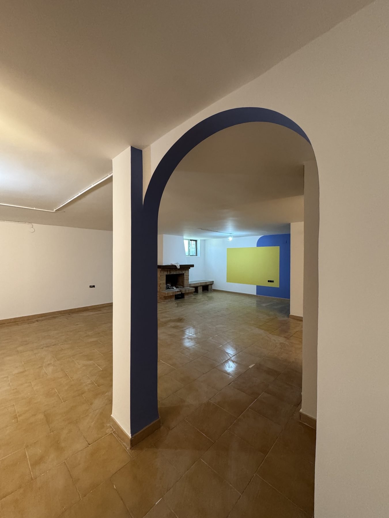 Interior con arco curvo y pintura bicolor azul y blanco en vivienda de Gandía